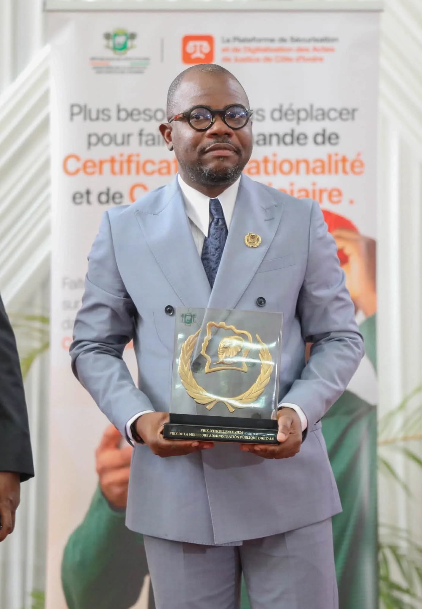 M. Auger Cadet Séoulou, coordonnateur des projets digitaux du ministère, avec le trophée